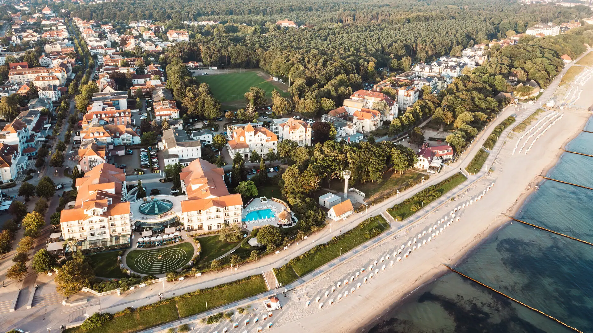 An aerial view of a town by the beach, showing the water and buildings.