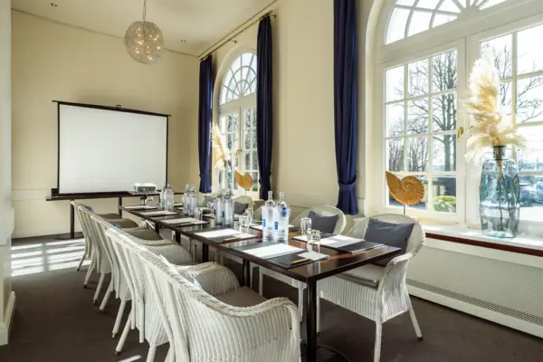 A room at the A-ROSA Travemünde with a table and chairs.