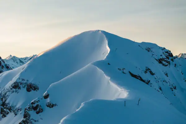 Schneebedeckter Berggipfel unter klarem Himmel.