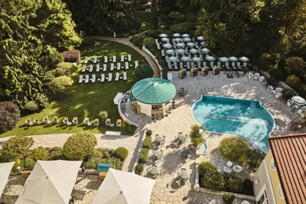A park with an outdoor pool, daybeds and a pool bar