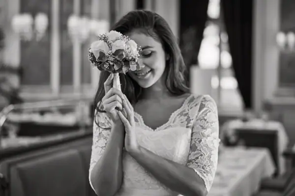 A woman in a wedding dress holding a bouquet of flowers.