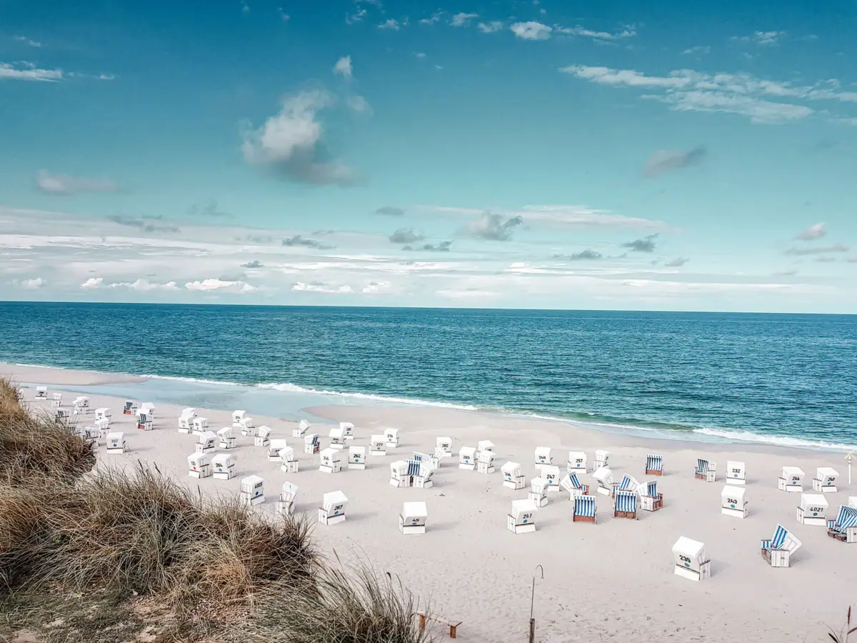 Strand mit Stühlen und Gewässer im Hintergrund