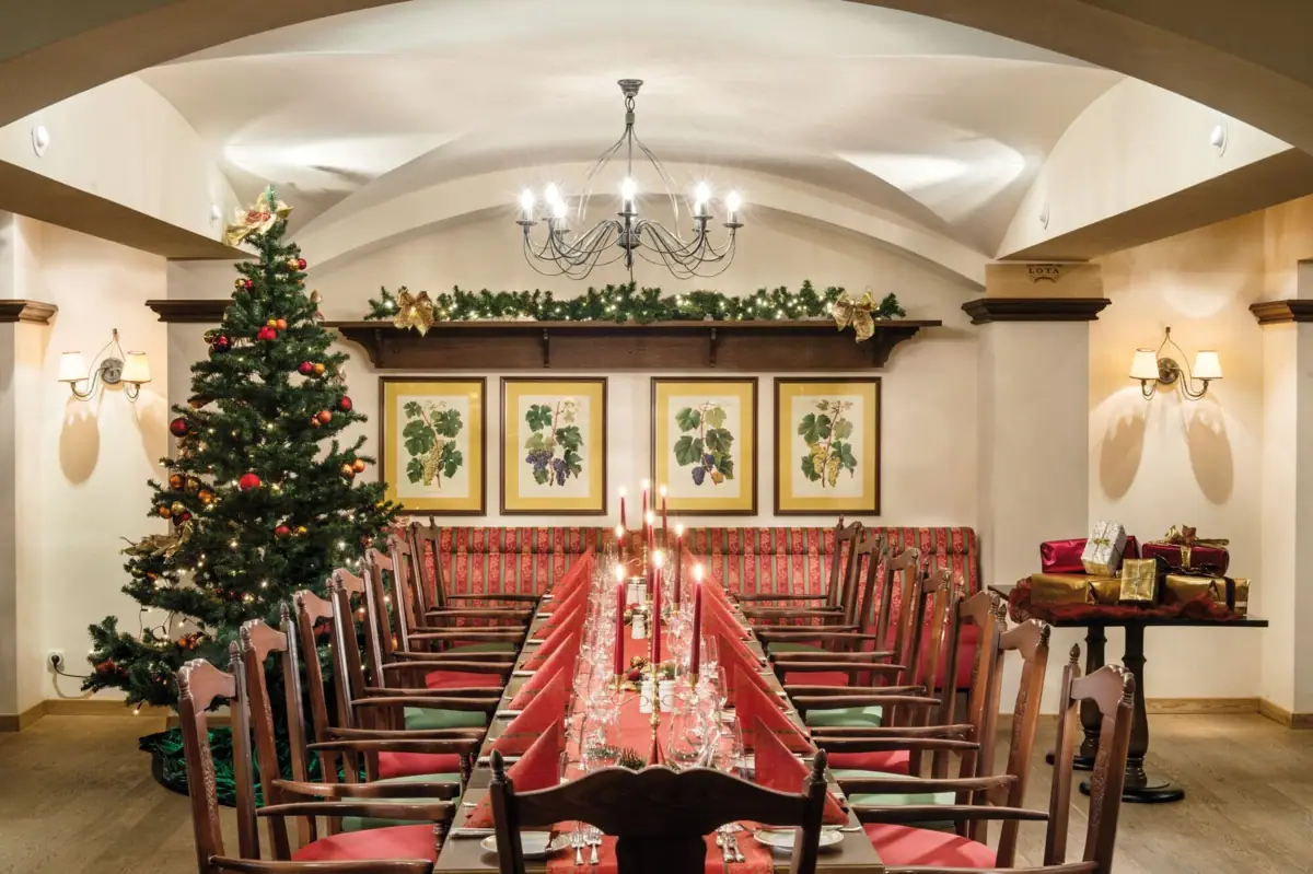Ein Zimmer mit einem Weihnachtsbaum und einem Tisch mit Stühlen.