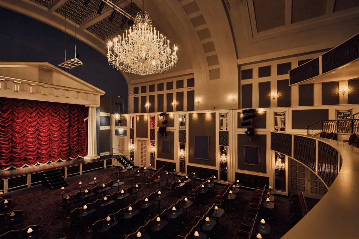 Großer Saal, fast wie im Theater mit Stühlen und Kronleuchtern.