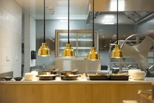Kitchen with hanging pans on the ceiling and visible sink.