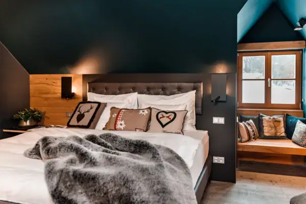 Ein Bett mit Kissen und Decke in einem Zimmer.