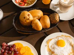 A table with a breakfast dish and crockery.