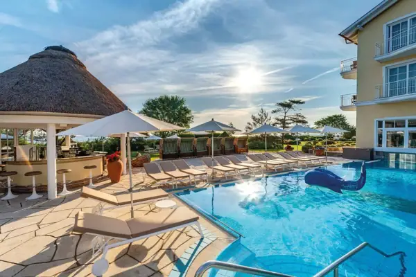 SPA-ROSA Ein Pool mit Liegestühlen und Sonnenschirmen.