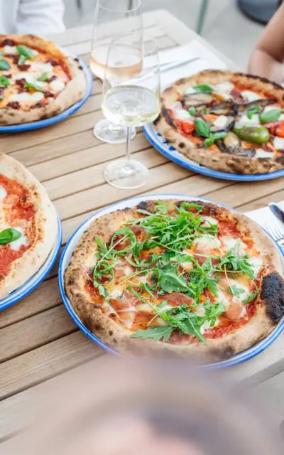 A table with pizza and wine glasses. 