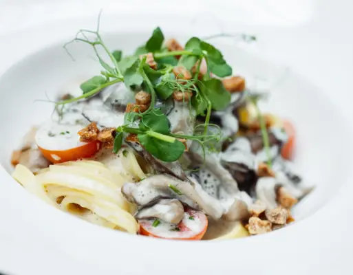 A plate of pasta, vegetables and sauce.