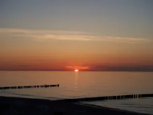 Sunset over a calm body of water at dusk.