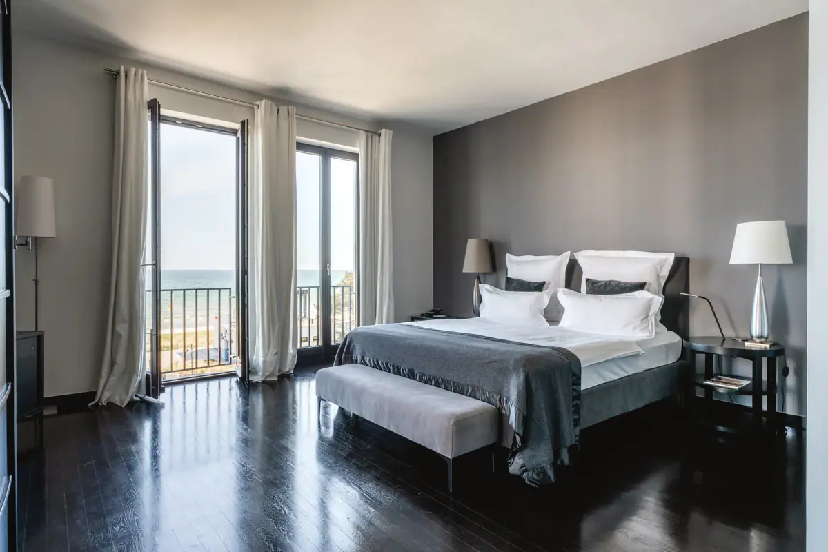 Ein Schlafzimmer mit großem Fenster und Blick auf den Ozean.
