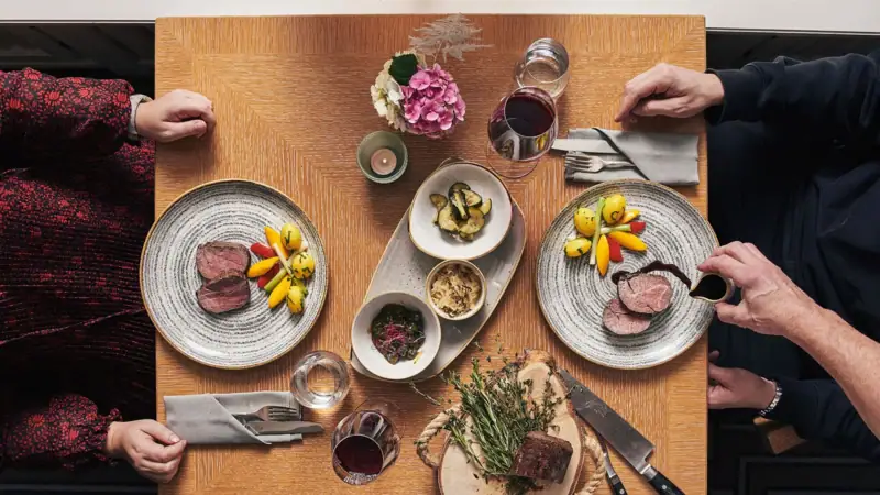 A group of people sitting at a table with plates of food.