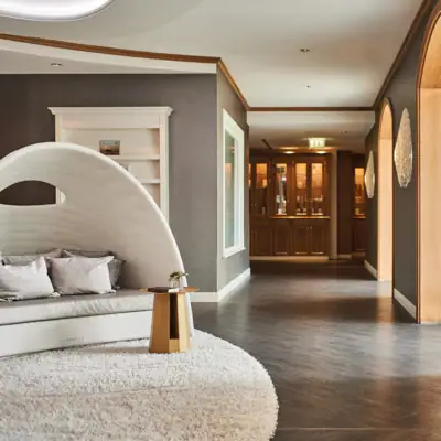 A hallway with a white rug and a white couch.