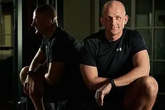 A man leaning back to back, showcasing physical fitness and muscle definition.