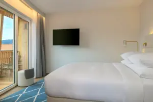 Sleeping area Bed with flat screen TV on the wall in a stylish room.