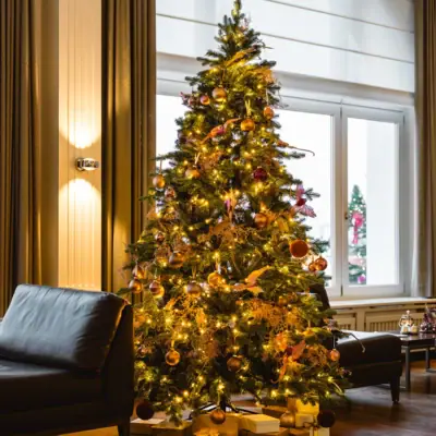 A Christmas tree in a room with festive decorations.