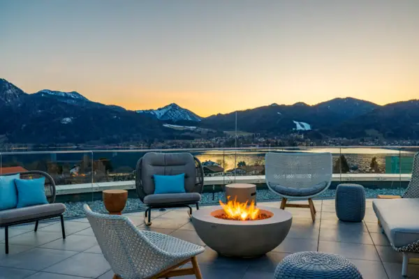 Fireplace with chairs and a view of the mountains in the background