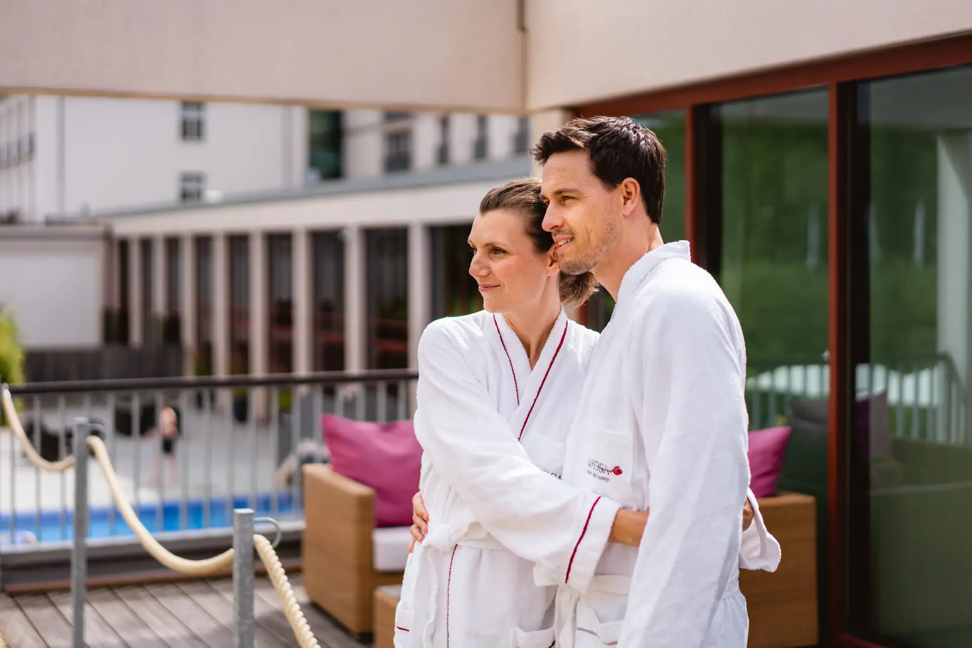 Couple Bathrobe A man and woman wearing white robes indoors.