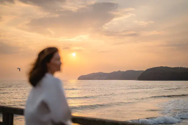 A woman is standing on the beach.