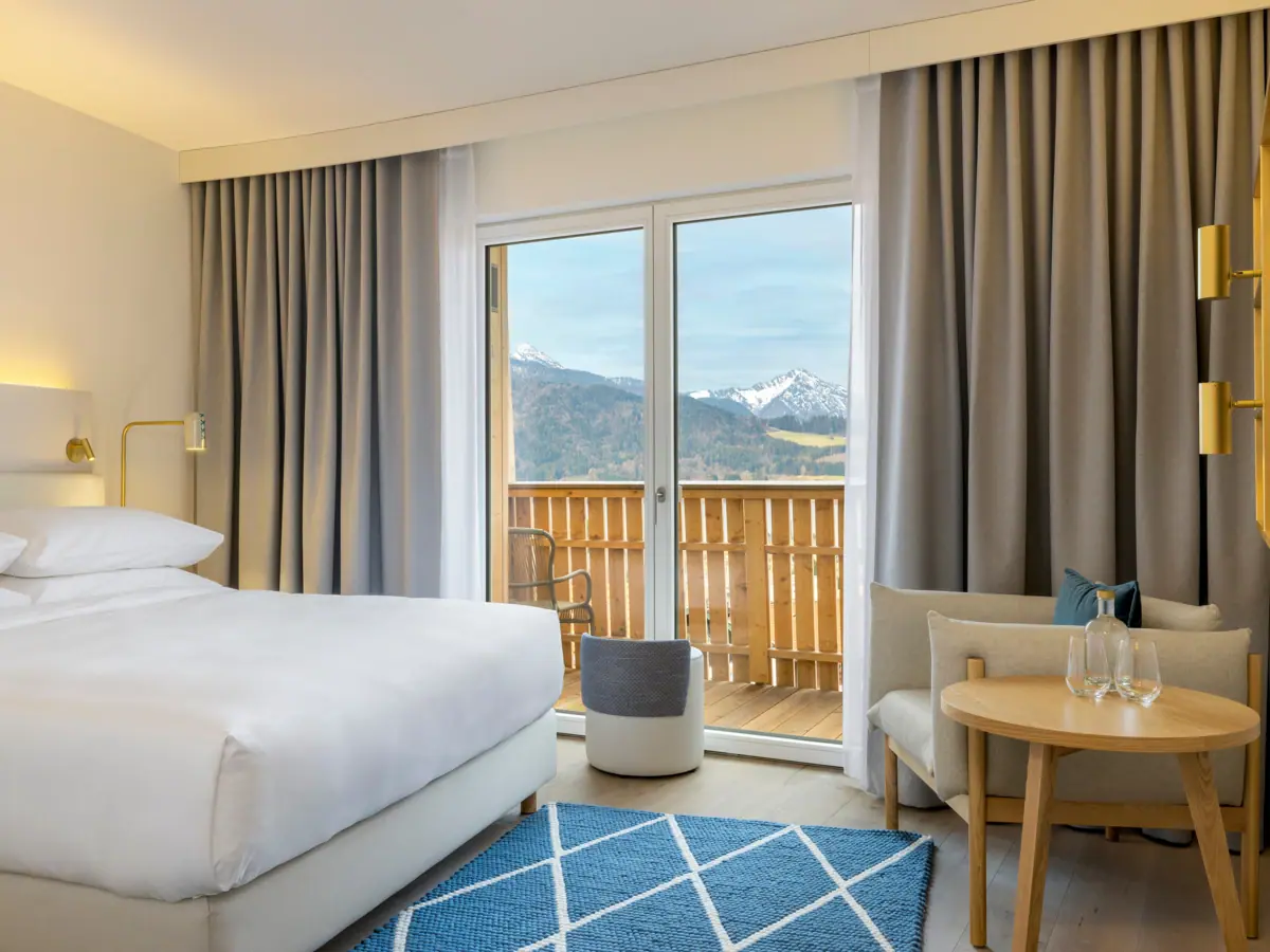 Hotel room with bed, carpet and armchair.