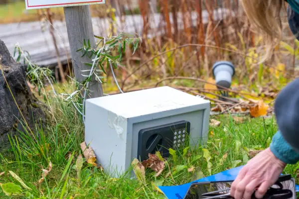 One person uses a tablet next to a safe.