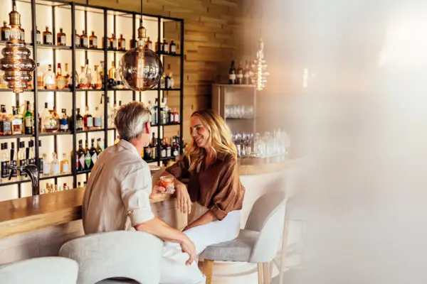 Bar A man and a woman are sitting at a bar.