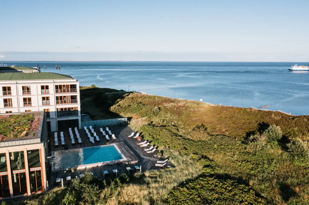 The outdoor pool at the A-ROSA Sylt, with the North Sea in the background.