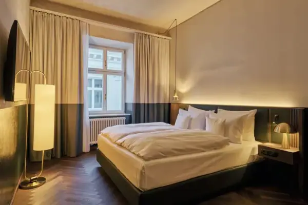 A neatly made bed with pillows and a duvet in a well-designed bedroom.
