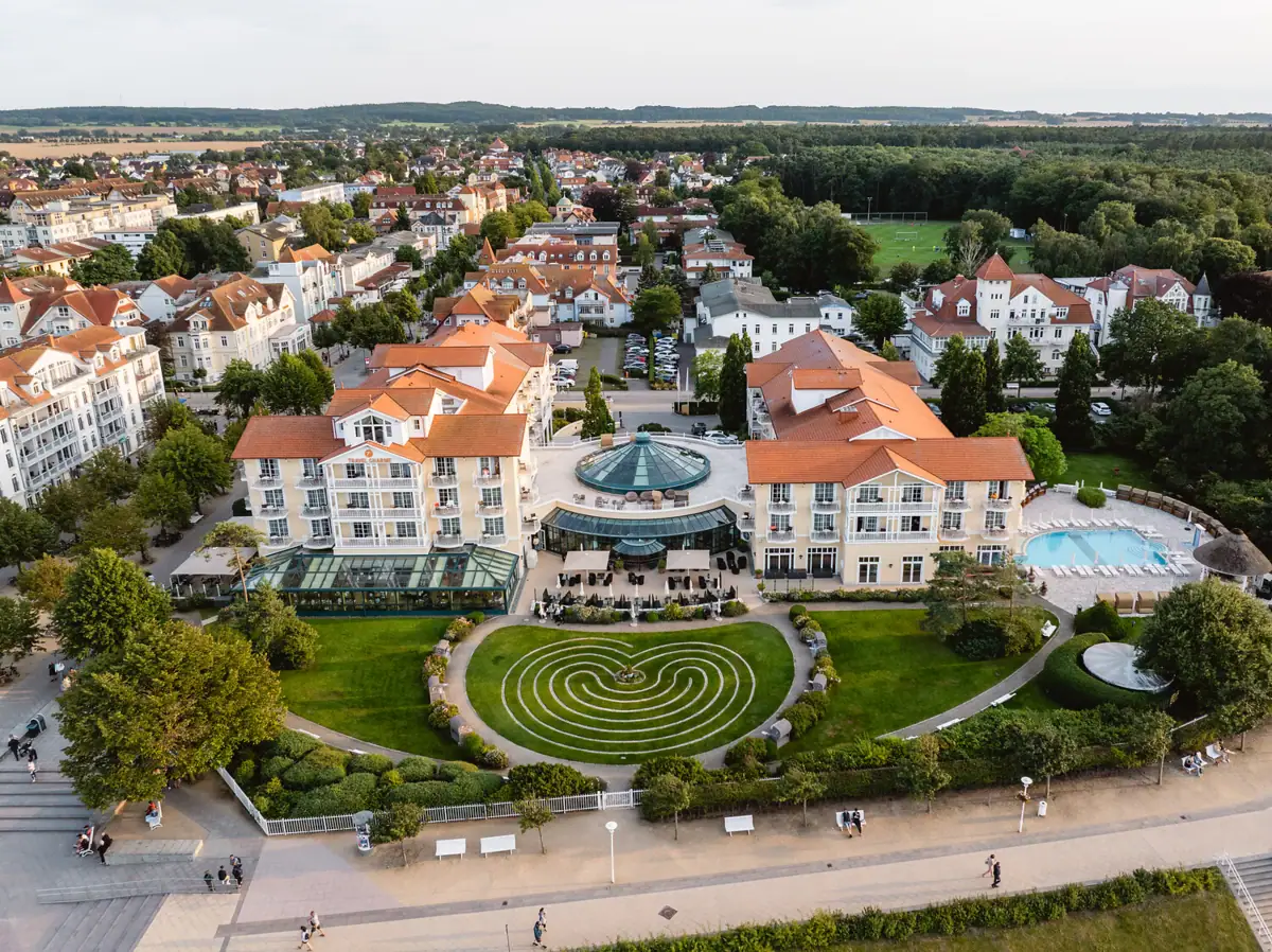A large group of buildings with a pool and surrounding grass.