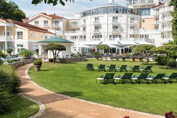 Deckchair in the garden with trees and a clear sky in the background.