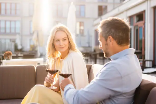 Ein Mann und eine Frau sitzen auf einem Sofa mit Weingläsern.