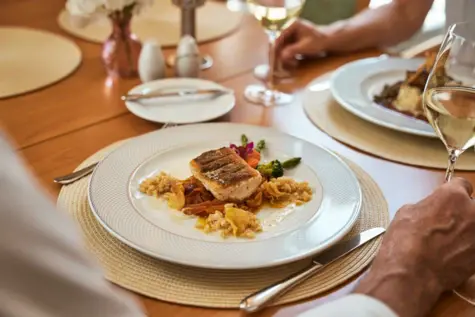 A plate of food and wine glasses on a table.