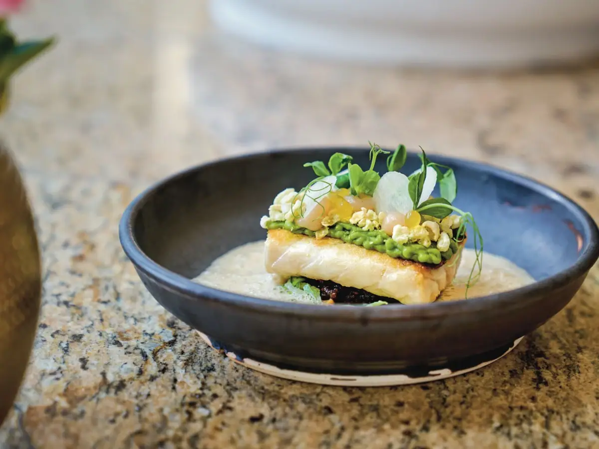 A plate of food with garnish on a counter.