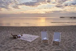 Ein Strand mit Stühlen und einer Decke.