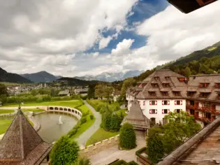 The view from a rooftop of a lake and the surrounding mountain landscape.