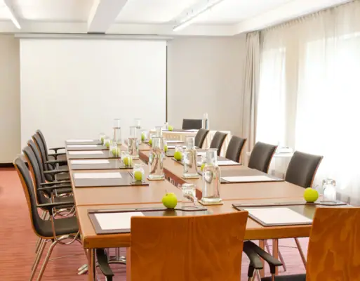 Konferenzraum mit Tisch und Stühlen.
