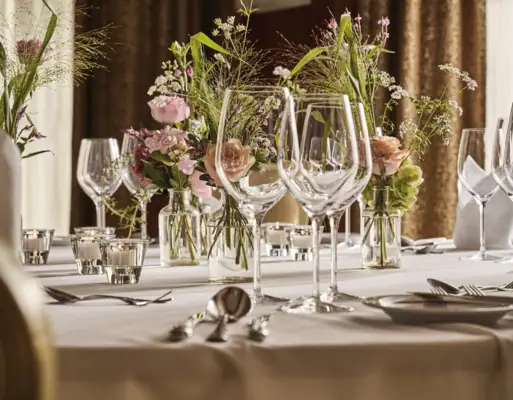 A table elegantly set with a floral centerpiece and candles.