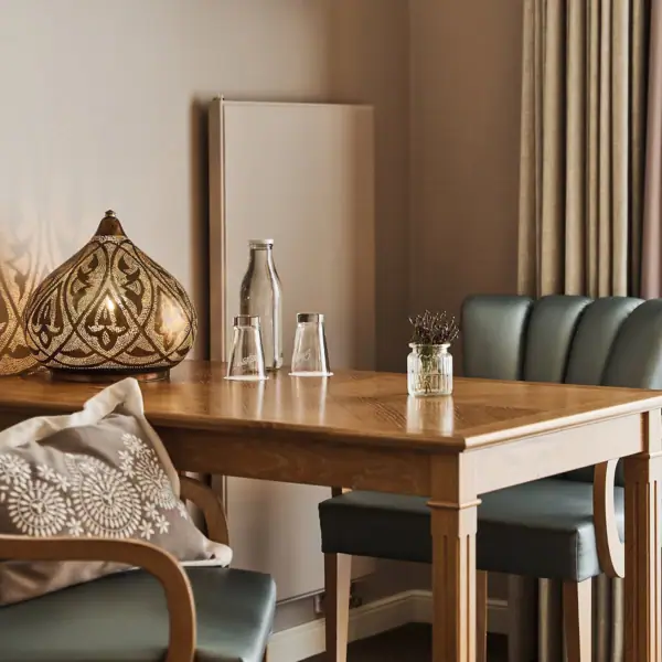 A table with a lamp and chairs in a well-designed indoor setting.