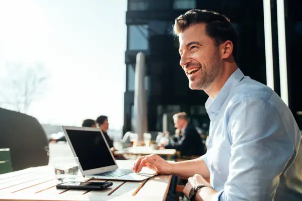 Ein Mann sitzt an einem Tisch mit einem Laptop.