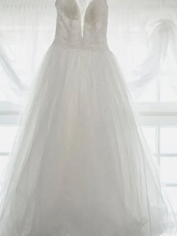 Wedding dress on a swing indoors with lace and embellishments.