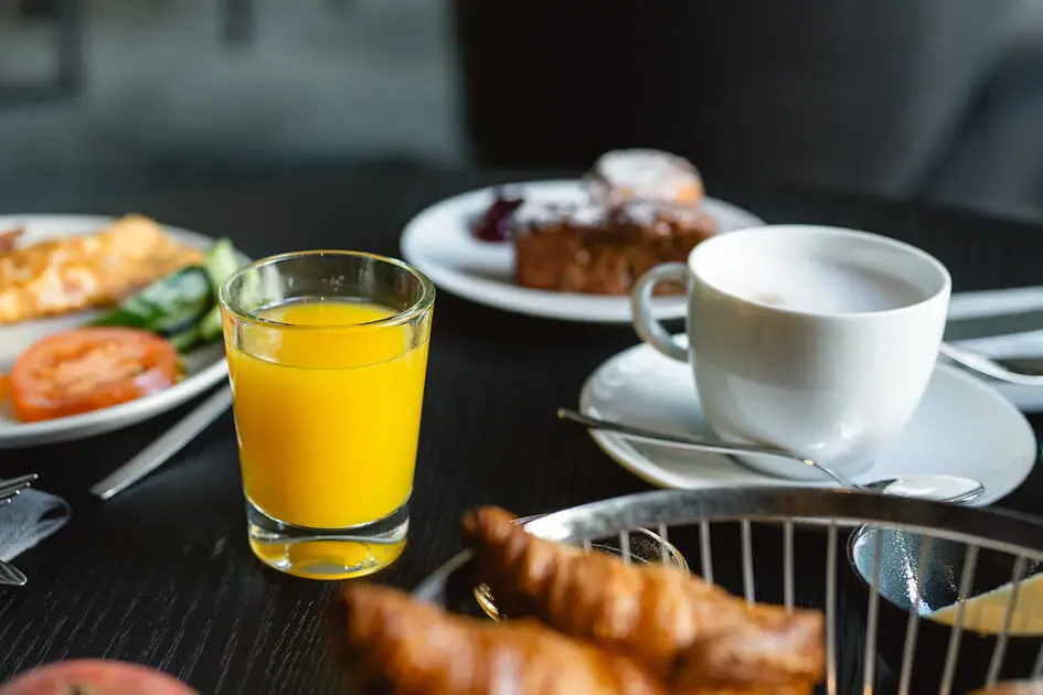 Breakfast Selection A plate of breakfast food and a glass of juice on a table.