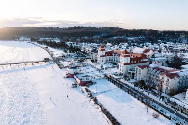 Schneebedeckte Stadt mit Gebäuden und einer Brücke.