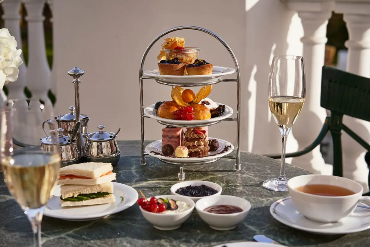 A table set with various dishes and drinks, featuring elegant tableware and serveware.