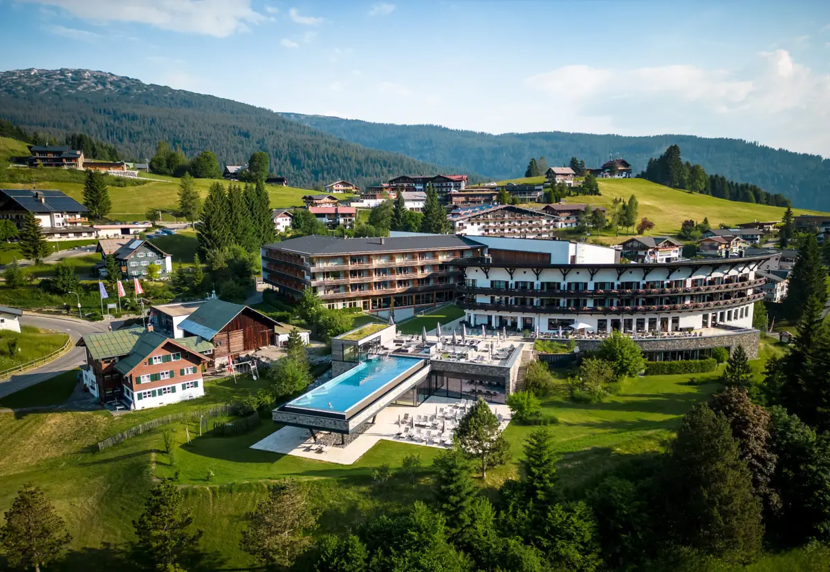 A-ROSA Ifen Hotel, Kleinwalsertal A house with a swimming pool in the mountains.