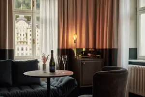 Ein Tisch mit Weingläsern und einer Lampe vor einem Fenster.