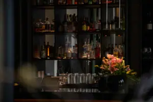 A shelf with bottles and glasses on it.