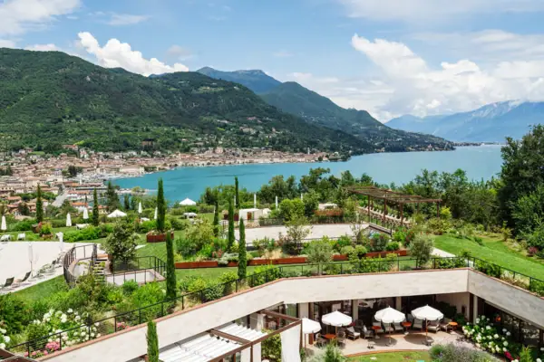 Ein Gebäude mit Garten und einem Gewässer im Vordergrund.