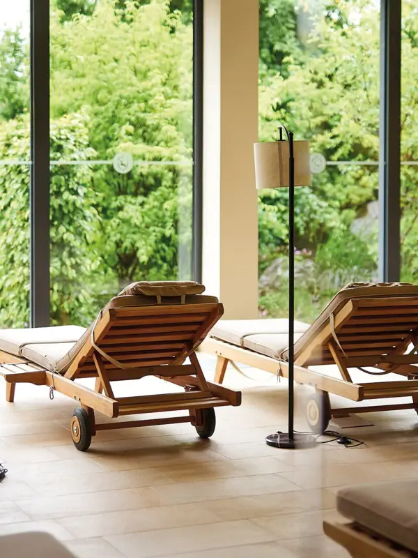 A lounge chair in a room with large windows.