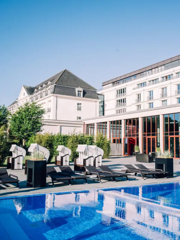 Ein Swimmingpool mit Liegestühlen und einem Gebäude im Hintergrund.
